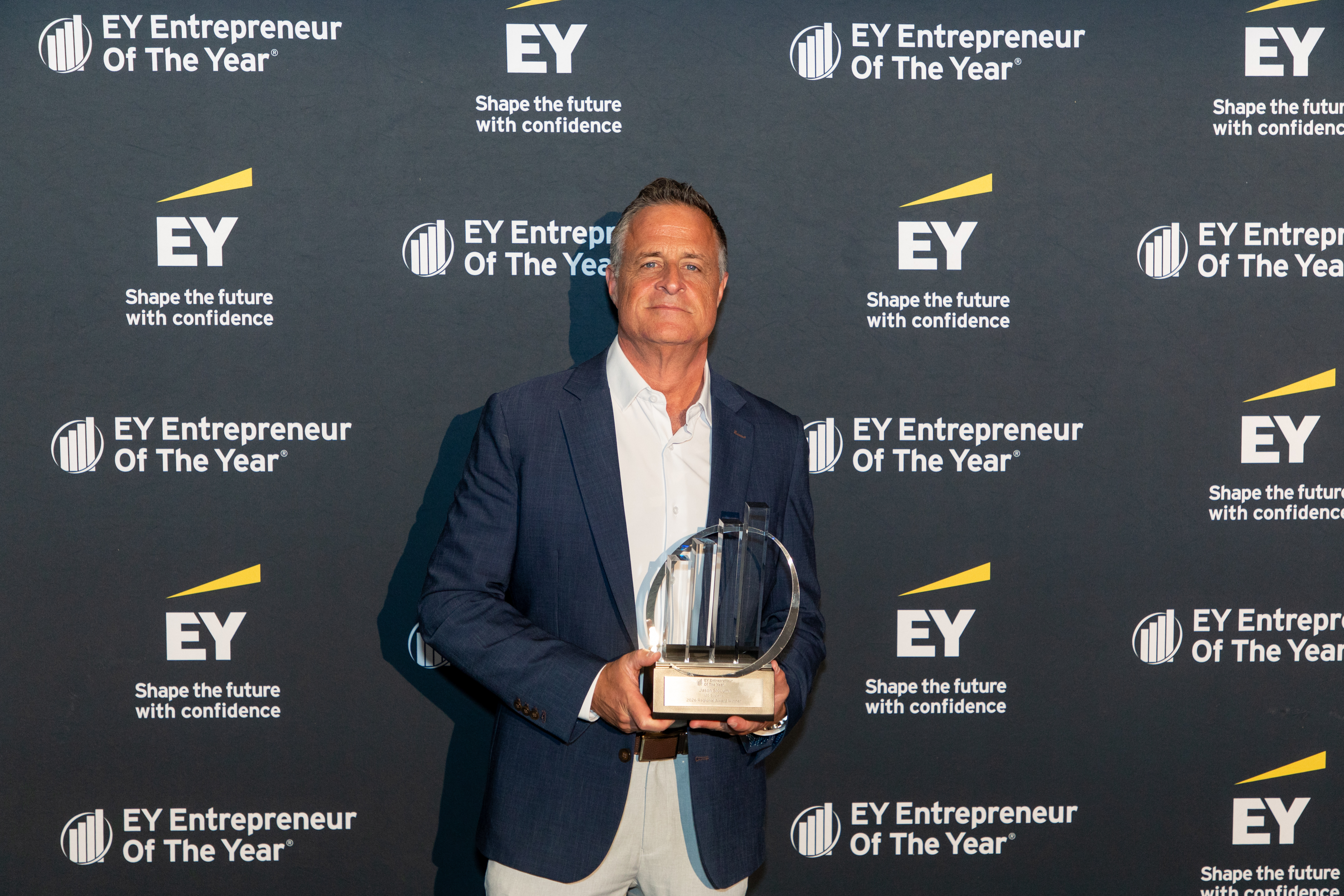 Jason Slocum of i2G Systems holding the EY Entrepreneur Of The Year 2026 Michigan and Northwest Ohio Award